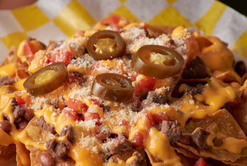 Loaded Supreme Nachos with jalapeños and sour cream